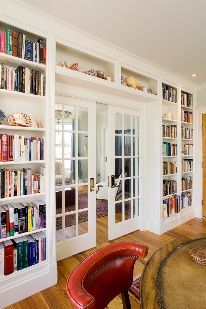 Large traditional enclosed living room in Portland Maine with a library, medium hardwood floors, a two-sided fireplace, a plaster fireplace surround and no tv.