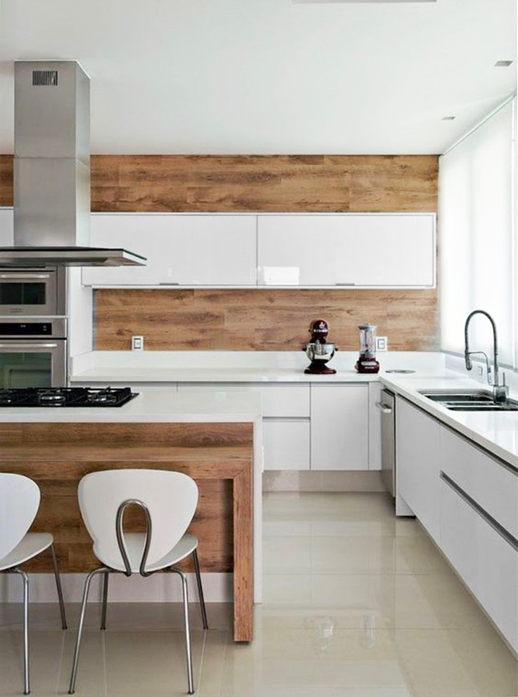 This is an example of a mid-sized modern l-shaped eat-in kitchen in Miami with an undermount sink, flat-panel cabinets, white cabinets, quartz benchtops, brown splashback, timber splashback, stainless steel appliances, marble floors, with island and beige floor.