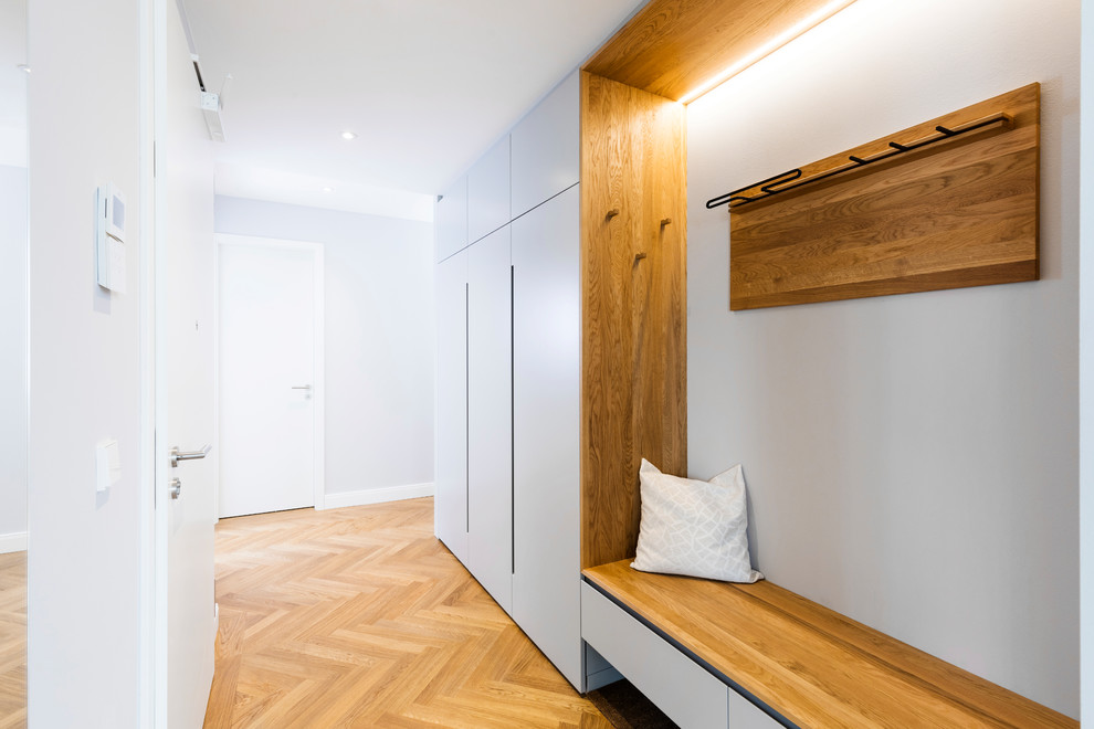 This is an example of a mid-sized scandinavian hallway in Munich with medium hardwood floors, brown floor and grey walls.