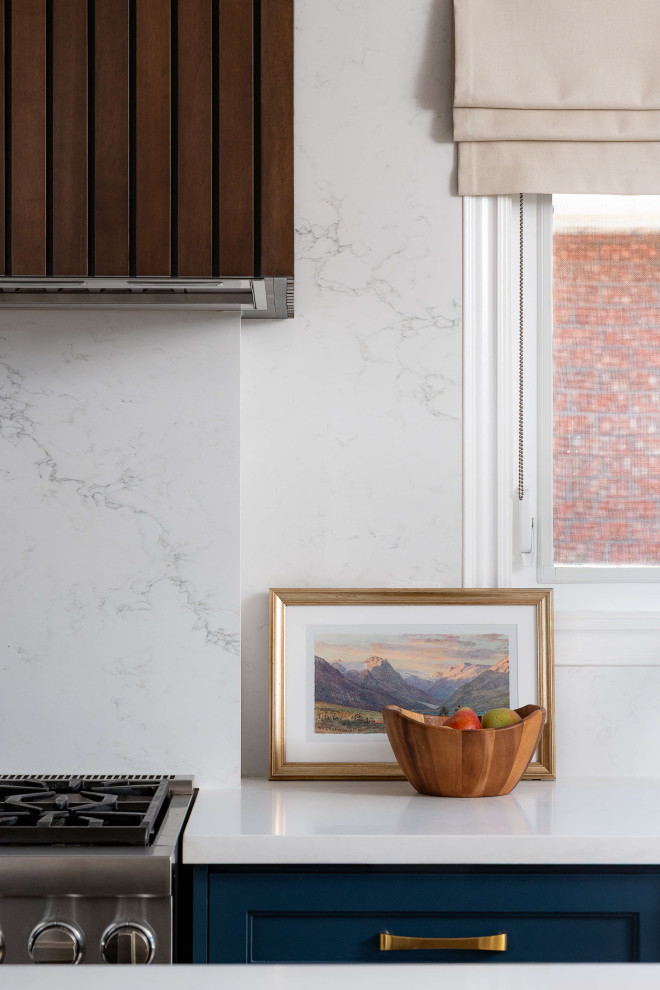 Mid-sized transitional l-shaped medium tone wood floor and beige floor eat-in kitchen photo in Toronto with a farmhouse sink, shaker cabinets, blue cabinets, quartz countertops, white backsplash, quartz backsplash, stainless steel appliances, an island and white countertops