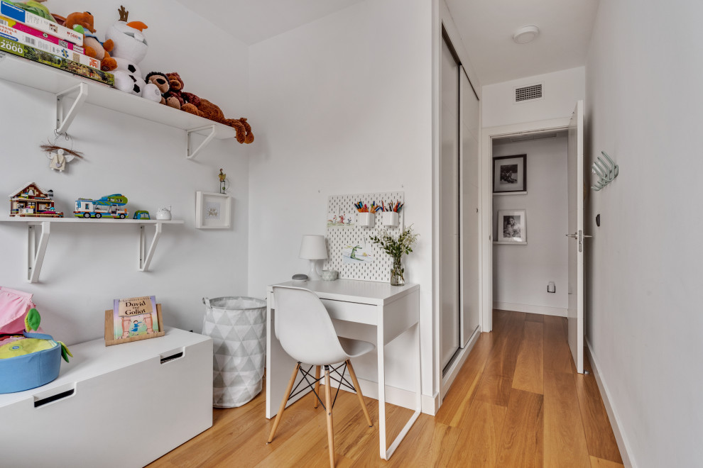Example of a small danish girl light wood floor and beige floor kids' room design in Madrid with white walls