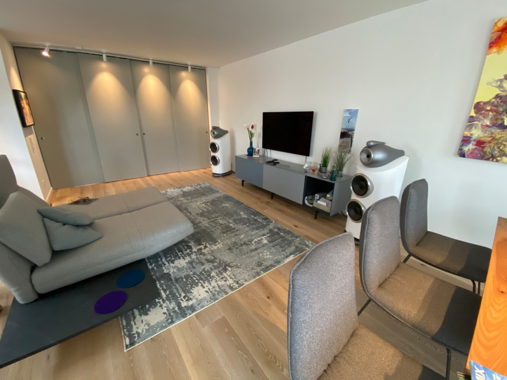 Mid-sized contemporary loft-style living room in Cologne with a music area, grey walls, light hardwood floors, a freestanding tv, beige floor, wallpaper and wallpaper.