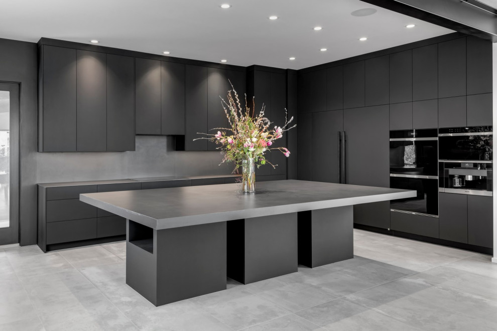 Inspiration for an expansive contemporary u-shaped kitchen in Calgary with a double-bowl sink, flat-panel cabinets, black cabinets, concrete benchtops, black splashback, cement tile splashback, black appliances, cement tiles, with island, black floor, black benchtop and exposed beam.