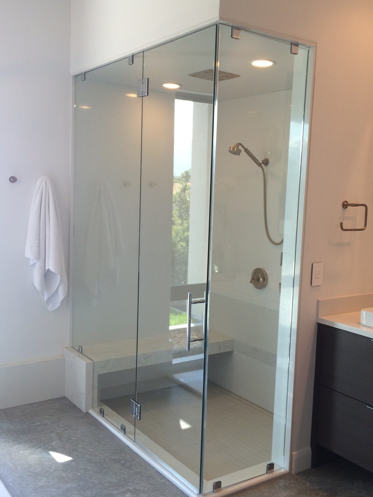 This is an example of a mid-sized contemporary 3/4 bathroom in Salt Lake City with flat-panel cabinets, dark wood cabinets, a drop-in tub, an alcove shower, white tile, porcelain tile, white walls, porcelain floors, a drop-in sink, solid surface benchtops, grey floor and a hinged shower door.