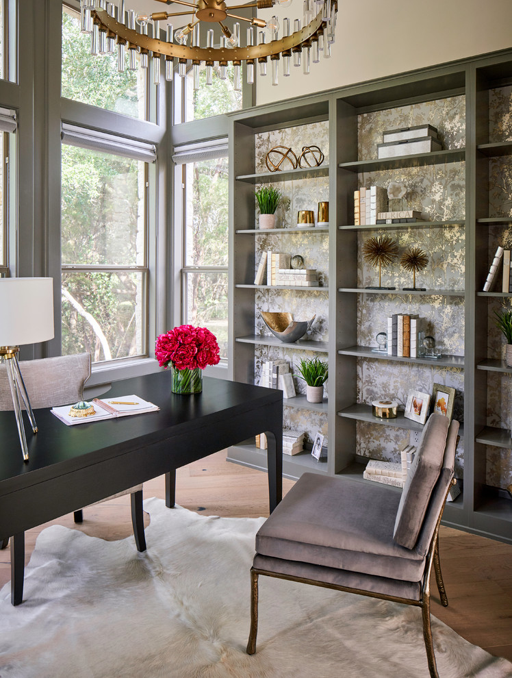 Design ideas for a mid-sized transitional home office in Austin with a library, grey walls, light hardwood floors, a freestanding desk and grey floor.
