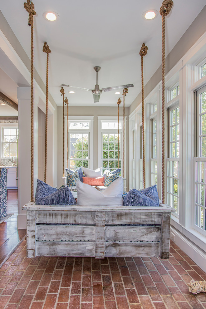 Inspiration for a mid-sized transitional sunroom in Other with brick floors, a standard fireplace, a wood fireplace surround, a standard ceiling and red floor.