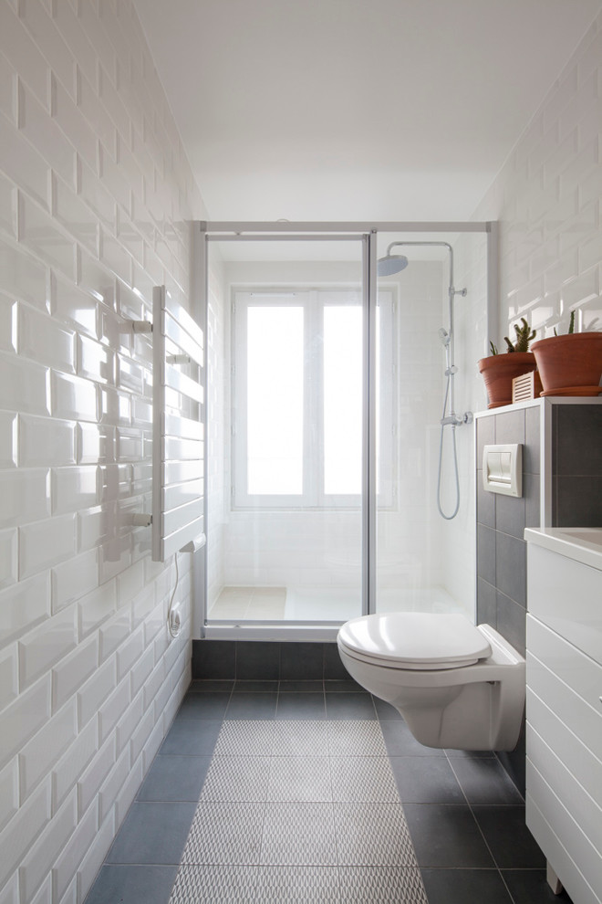 Inspiration for a mid-sized contemporary 3/4 bathroom in Paris with white cabinets, a wall-mount toilet, black and white tile, white walls, an alcove shower, subway tile and an undermount sink.