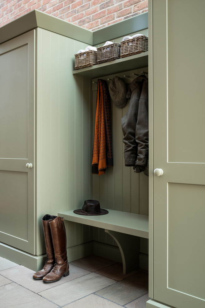 Photo of a mid-sized contemporary single-wall laundry cupboard in London with shaker cabinets, green cabinets and red floor.