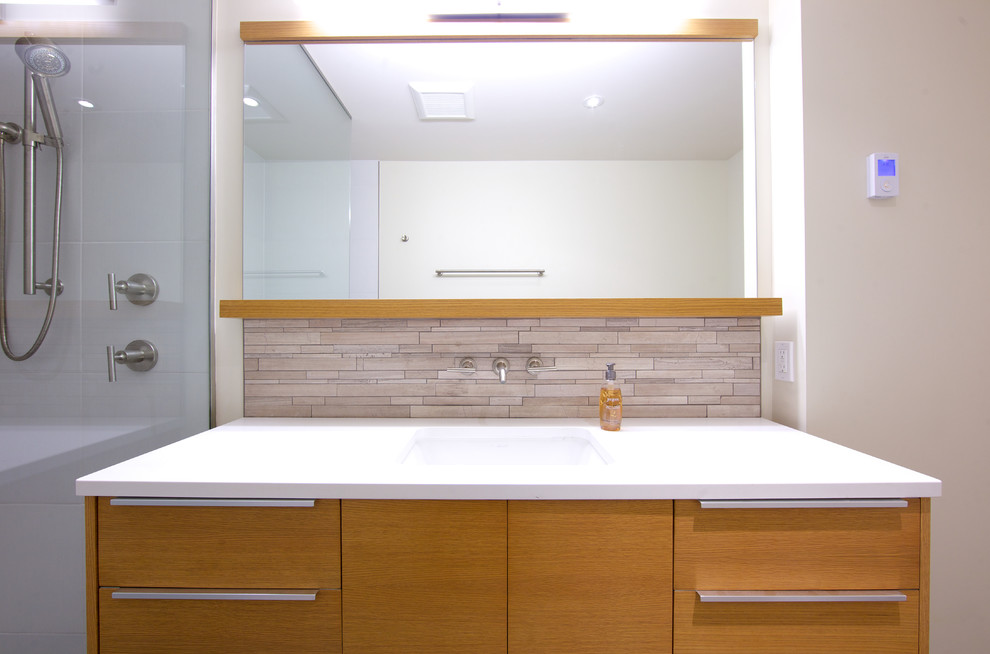 Contemporary master bathroom in Vancouver with flat-panel cabinets, light wood cabinets, gray tile, an integrated sink, concrete benchtops, a corner shower and beige walls.