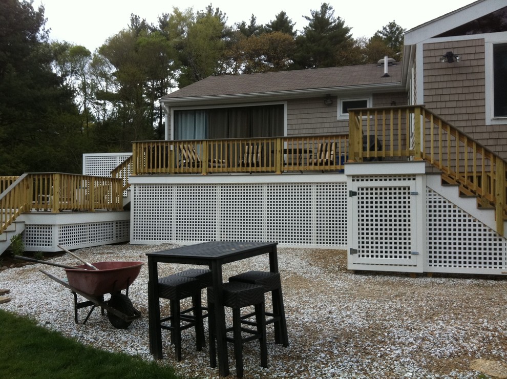 Example of a mid-sized backyard deck design in Boston with no cover