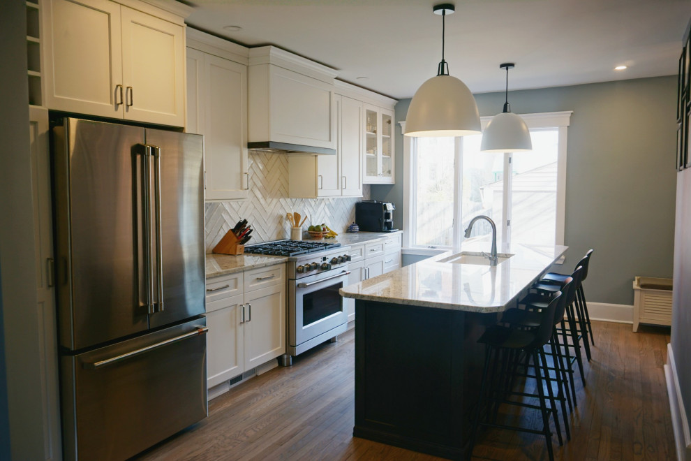 Eat-in kitchen - huge transitional light wood floor and brown floor eat-in kitchen idea with an undermount sink, shaker cabinets, white cabinets, granite countertops, white backsplash, ceramic backsplash, stainless steel appliances, an island and white countertops