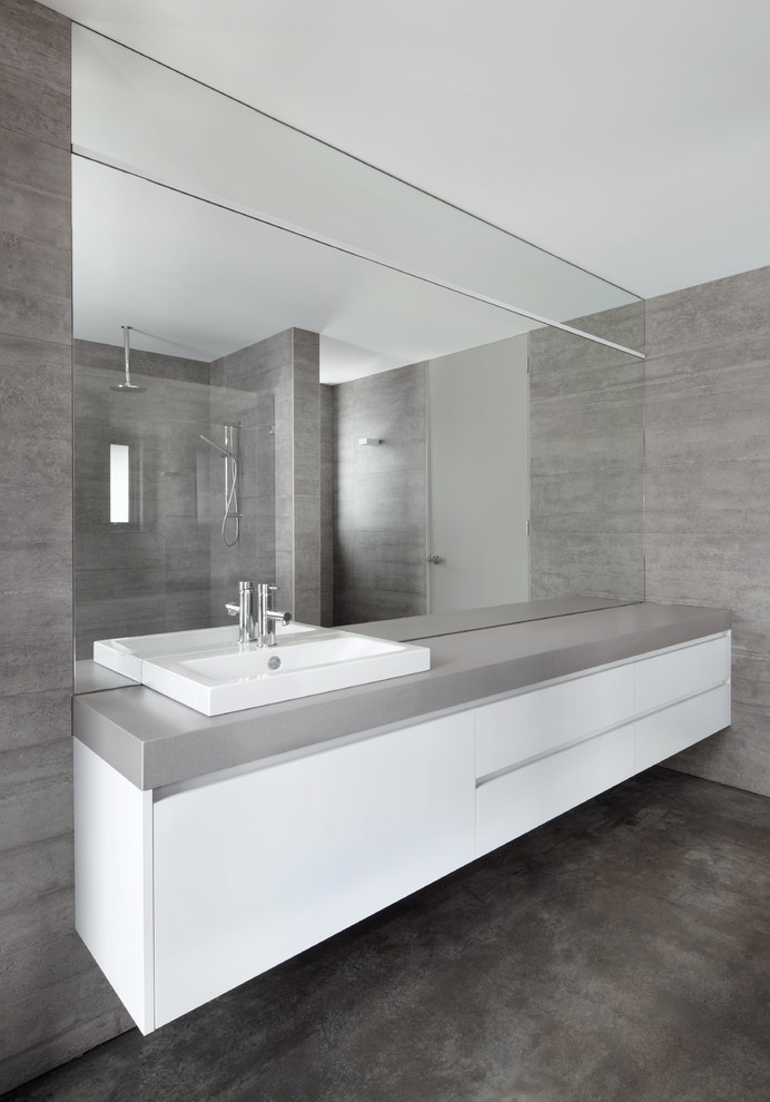 Photo of a mid-sized modern bathroom in Melbourne with white cabinets, an open shower, a one-piece toilet, gray tile, ceramic tile, grey walls, concrete floors, a drop-in sink, engineered quartz benchtops, grey floor, an open shower, grey benchtops, a single vanity and a floating vanity.