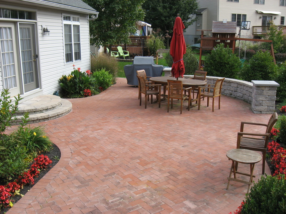 Photo of a mid-sized traditional backyard patio in Philadelphia with brick pavers and no cover.