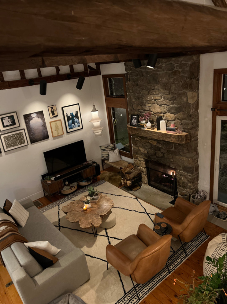 Источник вдохновения для домашнего уюта: гостиная комната в скандинавском стиле с паркетным полом среднего тона, стандартным камином, фасадом камина из камня и сводчатым потолком