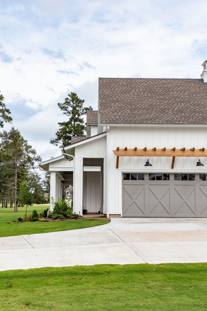 Photo of a large country two-storey white house exterior in Houston with concrete fiberboard siding, a hip roof, a shingle roof, a black roof and board and batten siding.