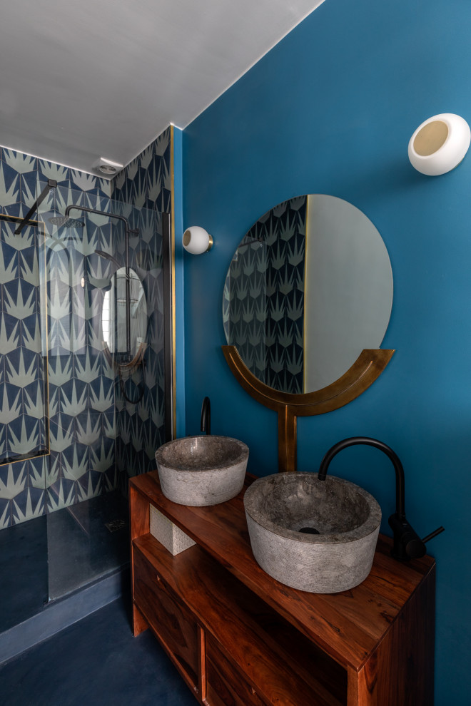 Bild på ett mellanstort shabby chic-inspirerat brun brunt en-suite badrum, med öppna hyllor, skåp i mellenmörkt trä, en kantlös dusch, blå kakel, cementkakel, blå väggar, betonggolv, ett fristående handfat, träbänkskiva, grått golv och med dusch som är öppen