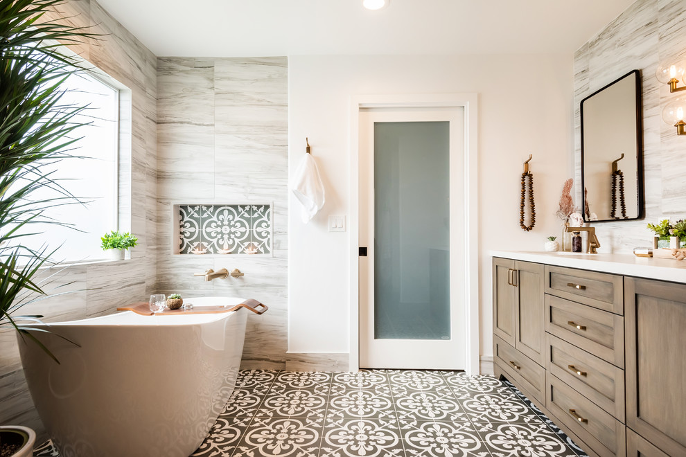 Design ideas for a beach style master bathroom in Los Angeles with shaker cabinets, medium wood cabinets, a freestanding tub, multi-coloured tile, white walls, multi-coloured floor and white benchtops.
