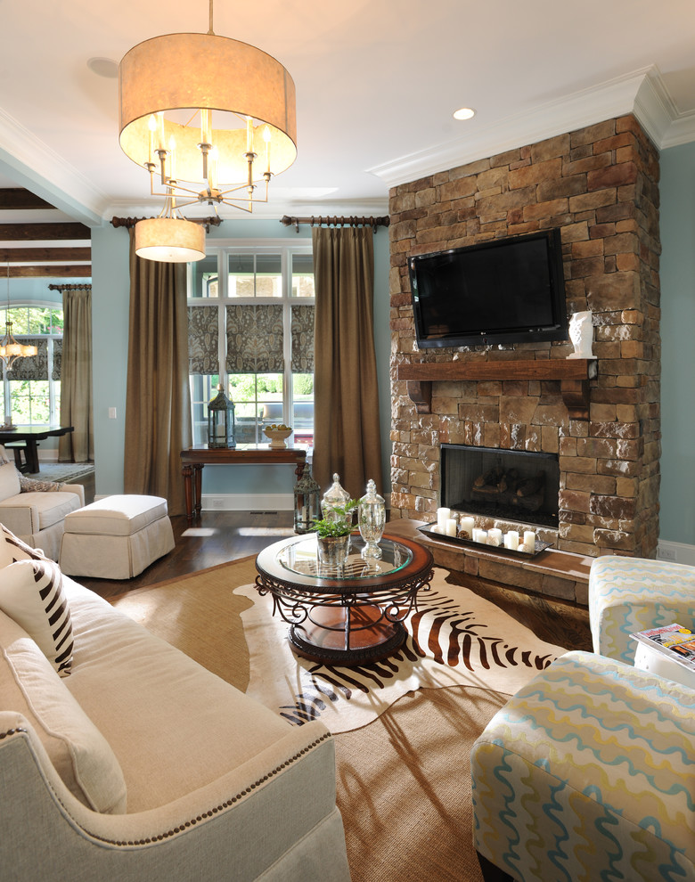 Traditional living room in Nashville with blue walls, a stone fireplace surround and a wall-mounted tv.