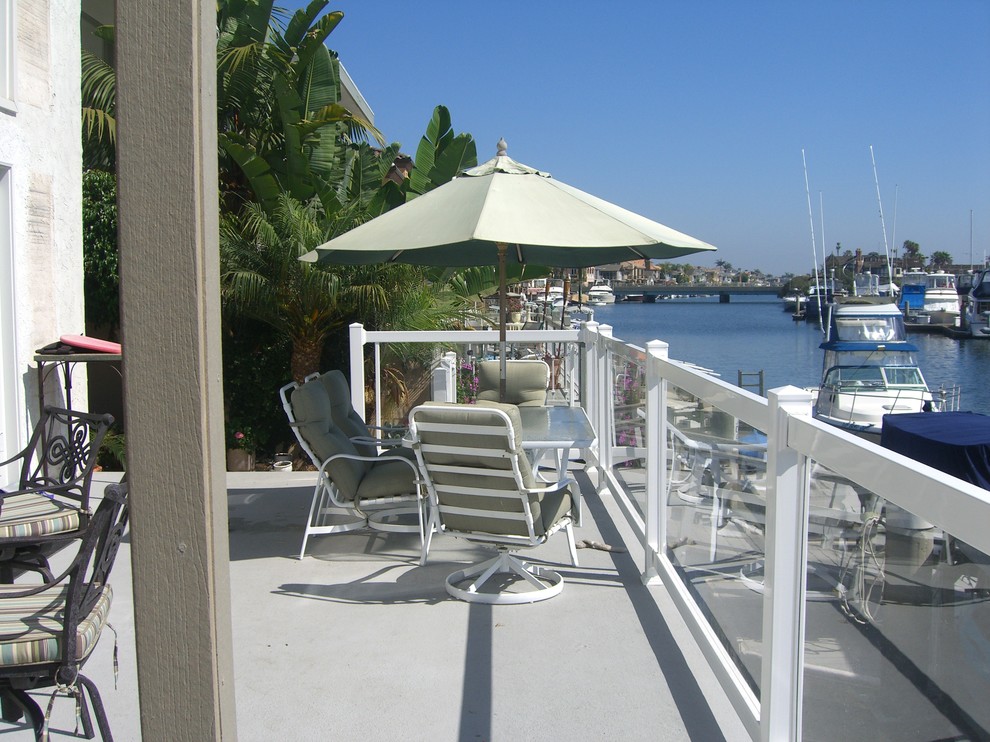 Inspiration for a large beach style backyard and ground level deck in Orange County with with dock and mixed railing.