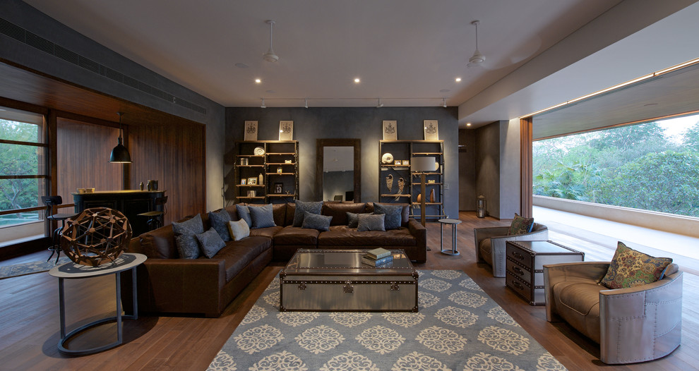 This is an example of a large contemporary living room in Ahmedabad with grey walls and dark hardwood floors.