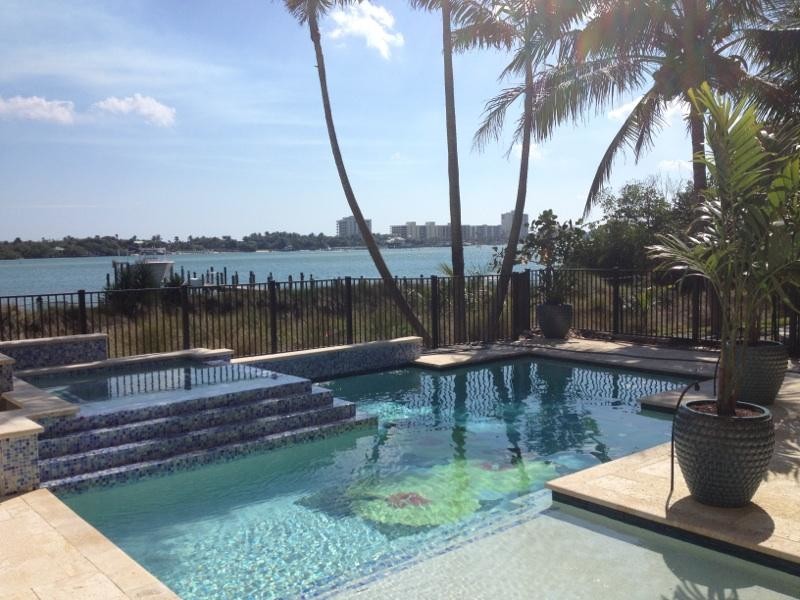 Large backyard custom-shaped natural hot tub photo in Miami