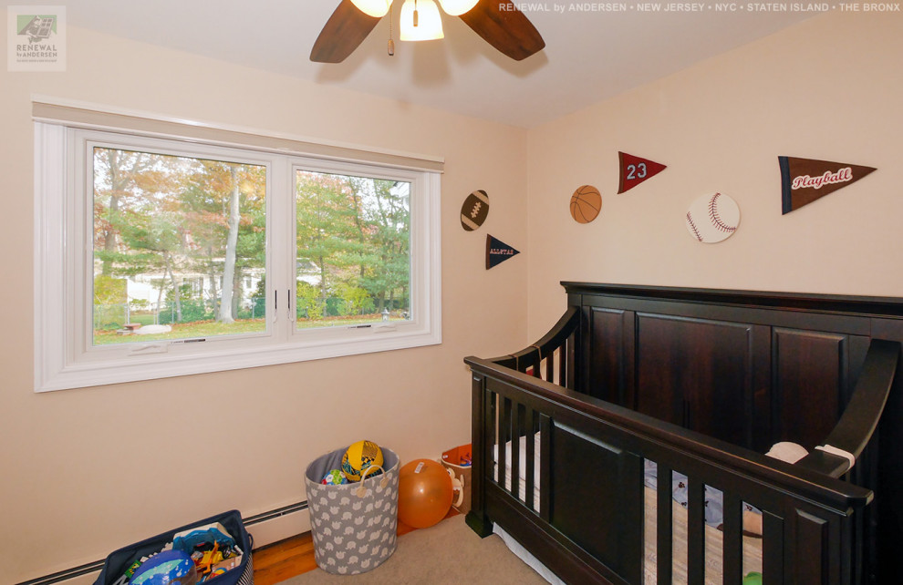 Inspiration for a mid-sized boy medium tone wood floor and multicolored floor nursery remodel in Newark with beige walls