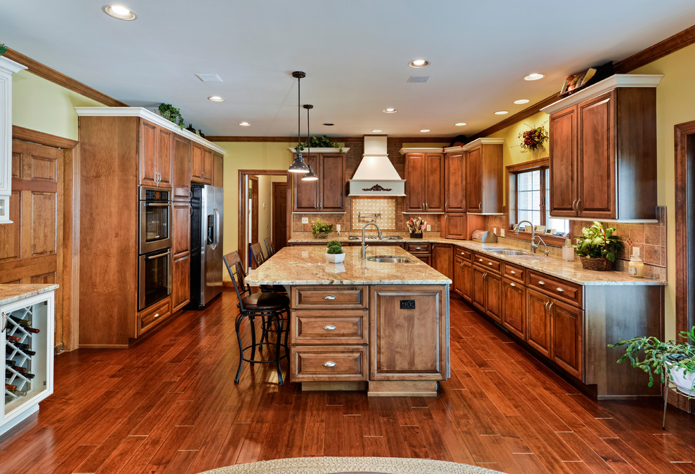 Eat-in kitchen - large transitional u-shaped medium tone wood floor eat-in kitchen idea with beaded inset cabinets, medium tone wood cabinets, granite countertops, beige backsplash, mosaic tile backsplash, stainless steel appliances and an island