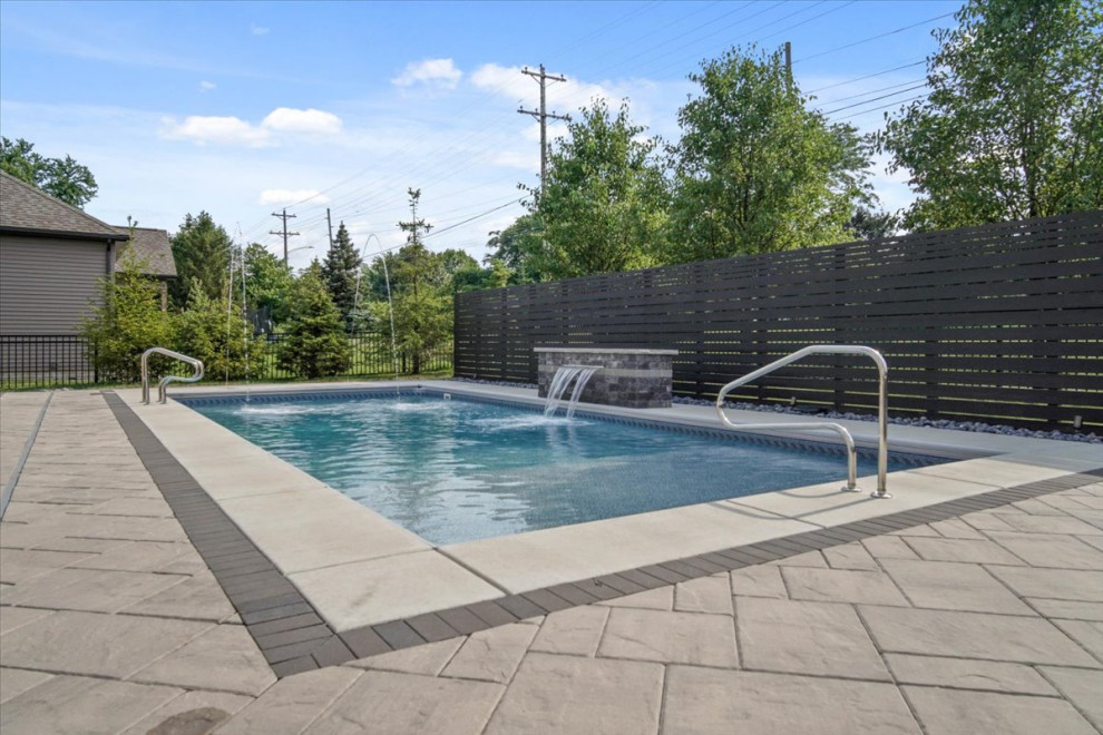 Пример оригинального дизайна: спортивный, прямоугольный бассейн среднего размера на заднем дворе в стиле модернизм с фонтаном и мощением тротуарной плиткой