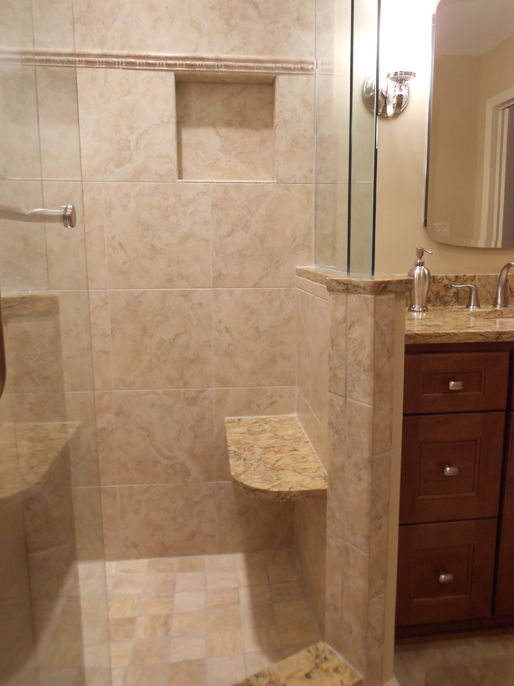 Photo of a mid-sized traditional master bathroom in Other with flat-panel cabinets, medium wood cabinets, porcelain tile, an undermount tub, a corner shower, a two-piece toilet, an undermount sink and porcelain floors.