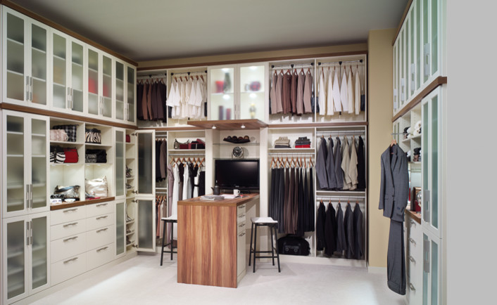 Photo of a large traditional gender-neutral walk-in wardrobe in Jacksonville with glass-front cabinets, white cabinets, carpet and white floor.