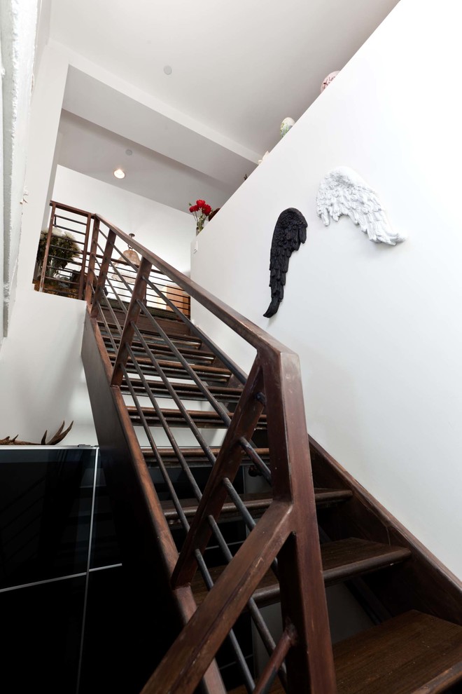 This is an example of a large industrial wood l-shaped staircase in Austin with open risers.