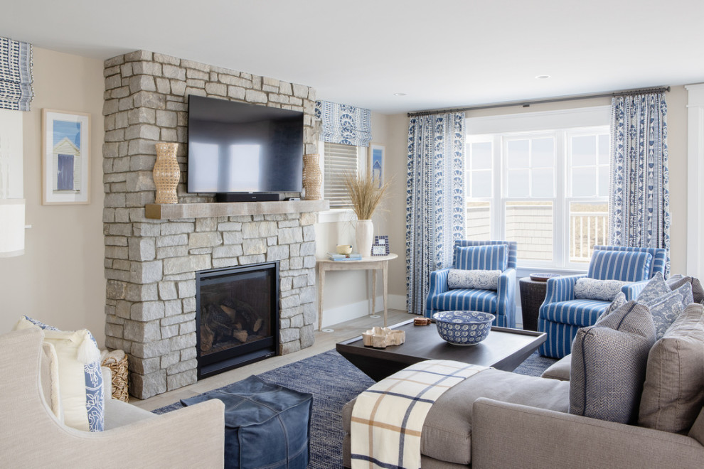 Inspiration for a large coastal open plan games room in Boston with beige walls, light hardwood flooring, a standard fireplace, a stone fireplace surround, a wall mounted tv and a chimney breast.
