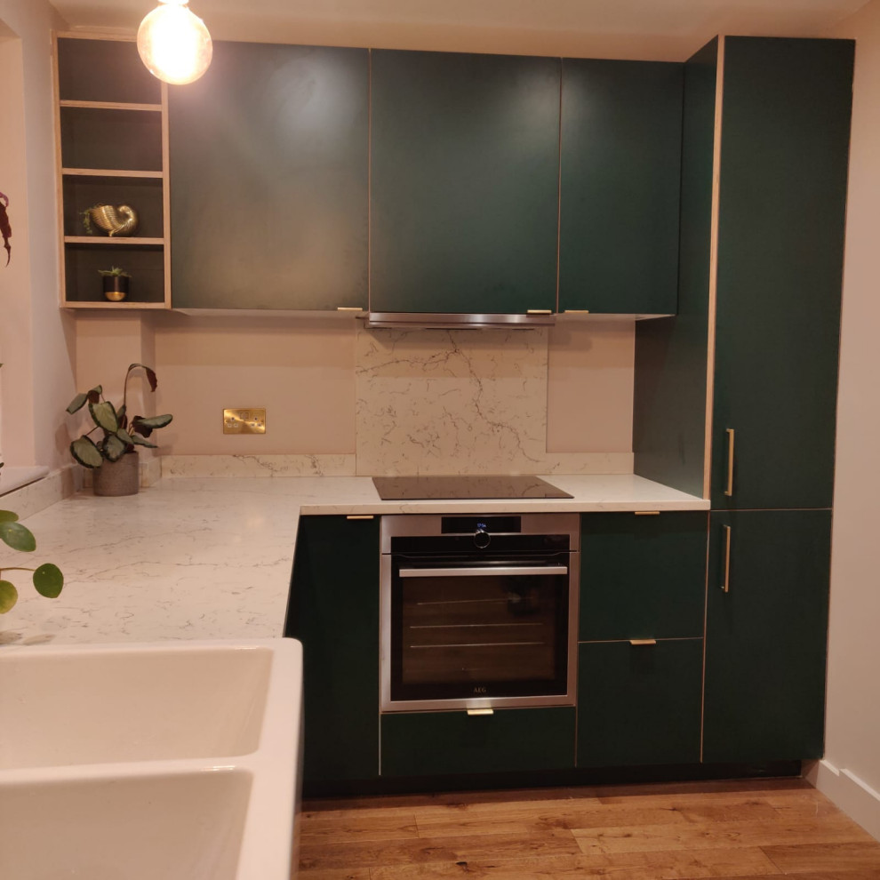 Design ideas for a large scandinavian l-shaped open plan kitchen in London with a belfast sink, flat-panel cabinets, white cabinets, quartz worktops, multi-coloured splashback, engineered quartz splashback, integrated appliances, laminate floors, multicoloured worktops and feature lighting.