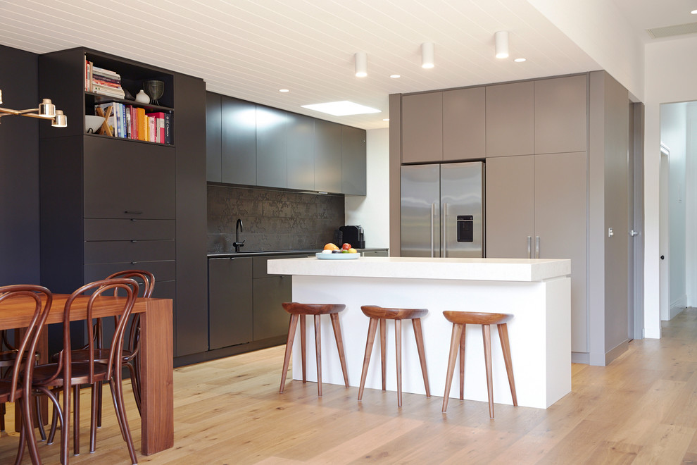 Photo of a contemporary kitchen in Melbourne with light hardwood floors and with island.
