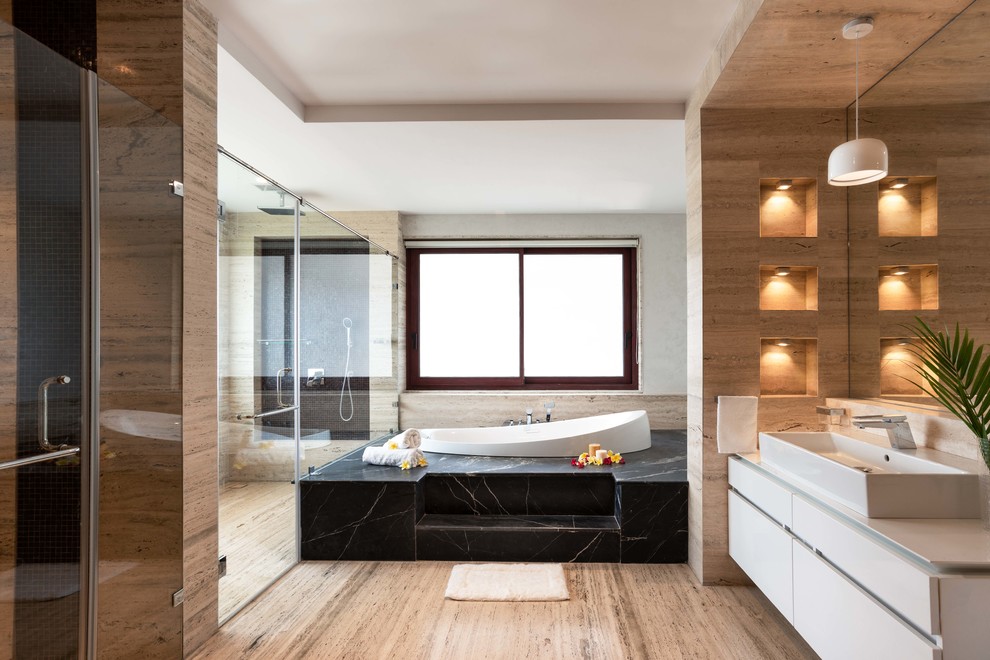 Large asian master bathroom in Bengaluru with a drop-in tub, beige tile, travertine, travertine floors, beige floor, white benchtops, flat-panel cabinets, white cabinets, a corner shower, a vessel sink and a hinged shower door.