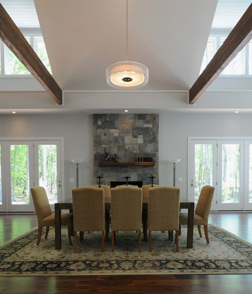 Example of a mid-sized transitional dark wood floor great room design with gray walls, a standard fireplace and a stone fireplace