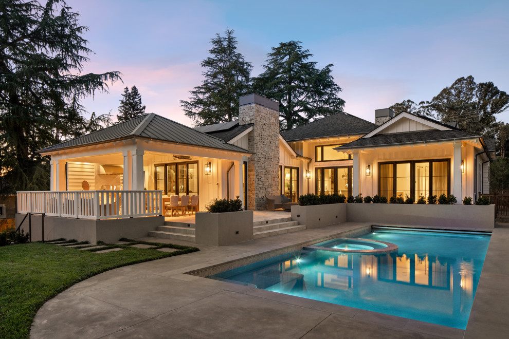 Imagen de piscinas y jacuzzis alargados de estilo de casa de campo rectangulares en patio trasero con adoquines de hormigón
