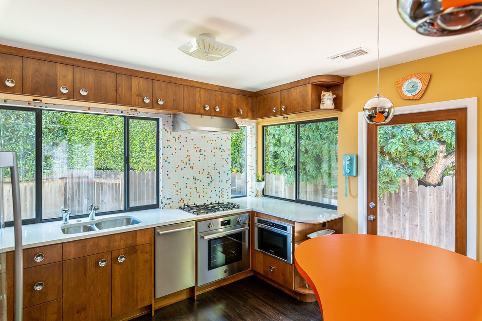 Photo of a small midcentury u-shaped eat-in kitchen in Los Angeles with an undermount sink, flat-panel cabinets, brown cabinets, quartz benchtops, multi-coloured splashback, glass sheet splashback, stainless steel appliances, dark hardwood floors, a peninsula, brown floor and multi-coloured benchtop.