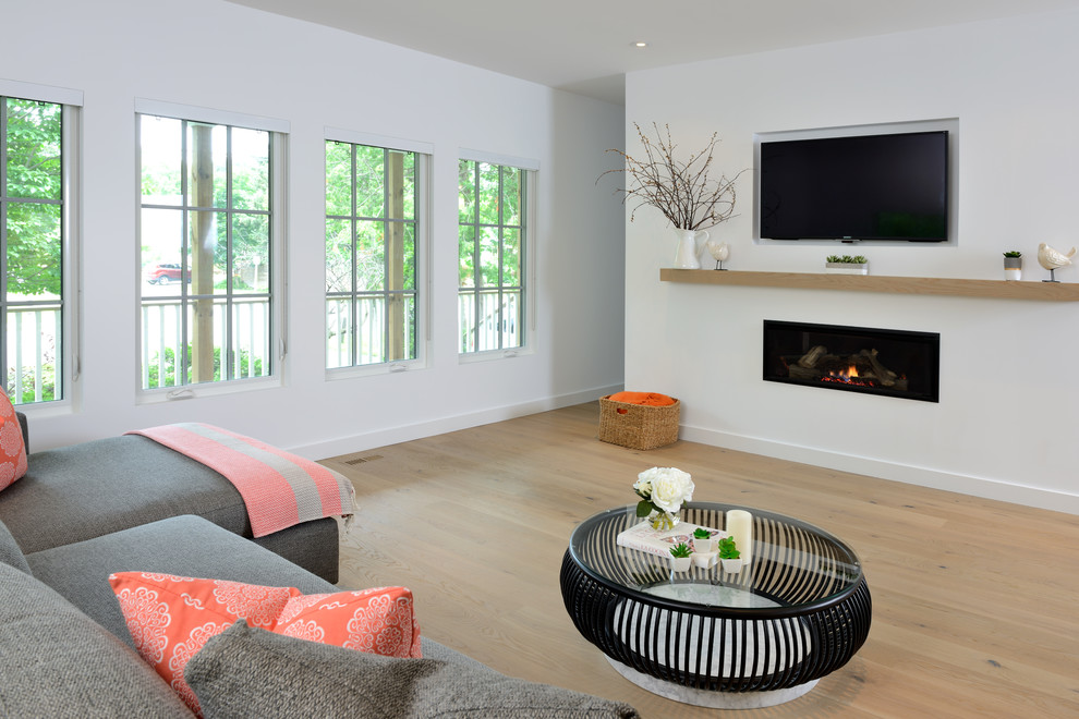 Design ideas for a mid-sized contemporary open concept family room in Toronto with white walls, light hardwood floors, a ribbon fireplace, a plaster fireplace surround and beige floor.
