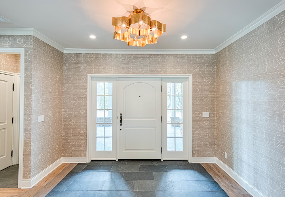 Photo of a mid-sized transitional foyer in Los Angeles with white walls, slate floors, a single front door, a white front door and grey floor.
