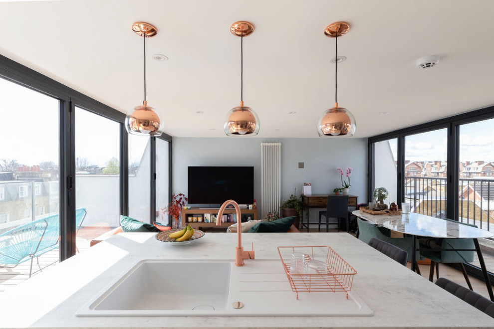 Cette image montre une cuisine ouverte parallèle et grise et rose minimaliste de taille moyenne avec des portes de placard grises, une crédence blanche, une crédence en céramique, parquet foncé, îlot et un sol marron.