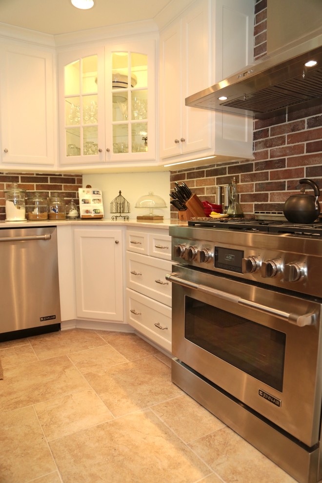 Inspiration for a mid-sized timeless l-shaped ceramic tile and beige floor eat-in kitchen remodel in Kansas City with shaker cabinets, white cabinets, granite countertops, multicolored backsplash, stone tile backsplash, stainless steel appliances, an island and an undermount sink