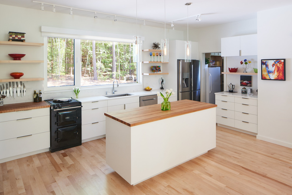 This is an example of a small contemporary l-shaped eat-in kitchen in Raleigh with an undermount sink, flat-panel cabinets, white cabinets, quartz benchtops, white splashback, marble splashback, stainless steel appliances, light hardwood floors, with island, white benchtop and beige floor.