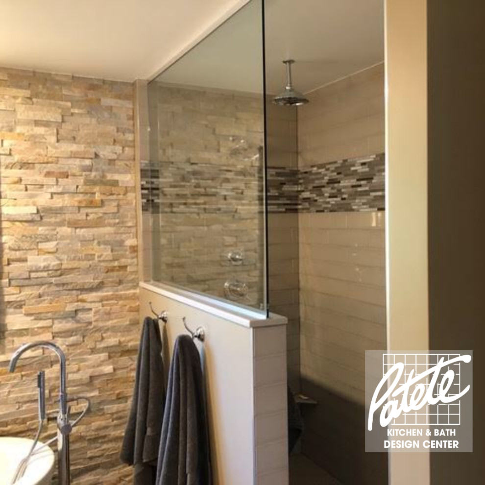 Idée de décoration pour une salle de bain design avec un espace douche bain, un carrelage multicolore, des dalles de pierre, un mur beige et aucune cabine.