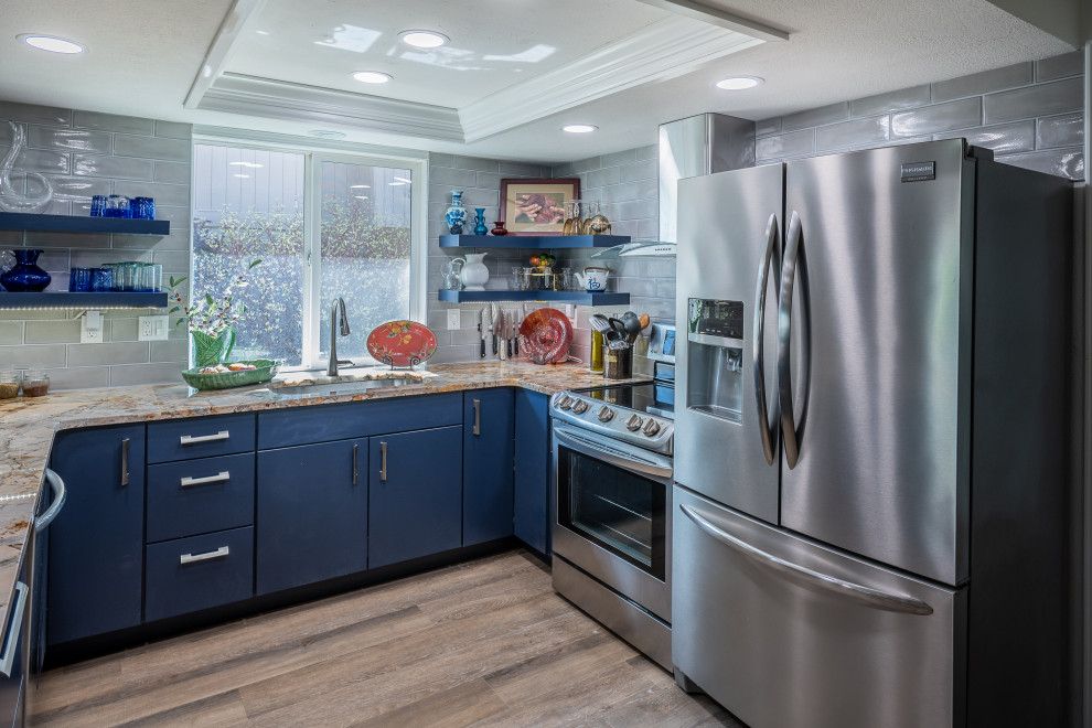 Bild på ett litet funkis flerfärgad flerfärgat kök, med en undermonterad diskho, släta luckor, blå skåp, marmorbänkskiva, grått stänkskydd, stänkskydd i tunnelbanekakel, rostfria vitvaror, ljust trägolv och flerfärgat golv