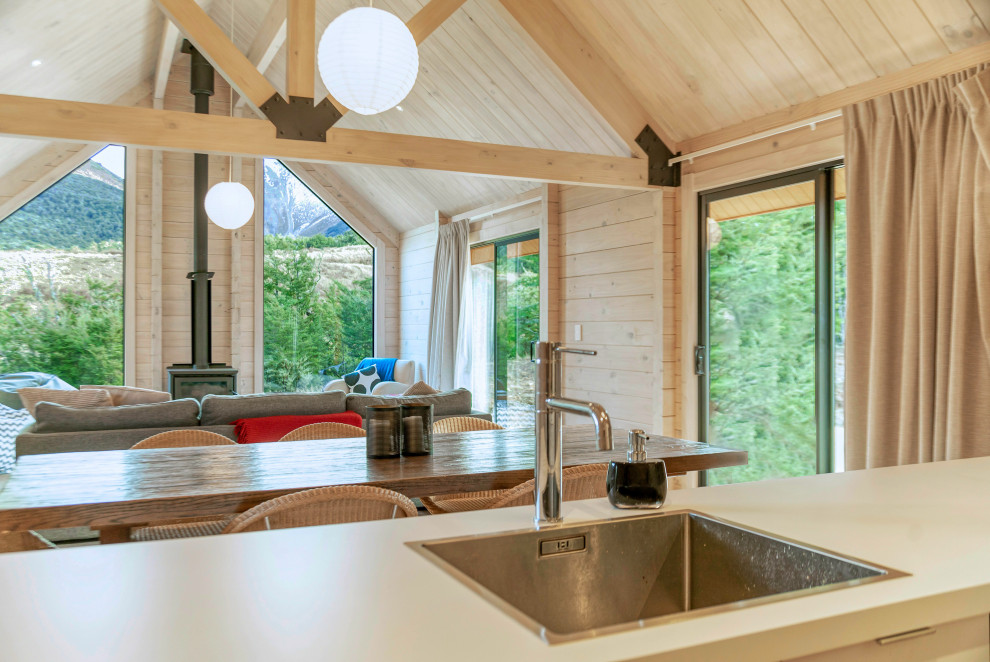 Modelo de cocina comedor de estilo de casa de campo de tamaño medio con suelo de madera en tonos medios, una isla y machihembrado