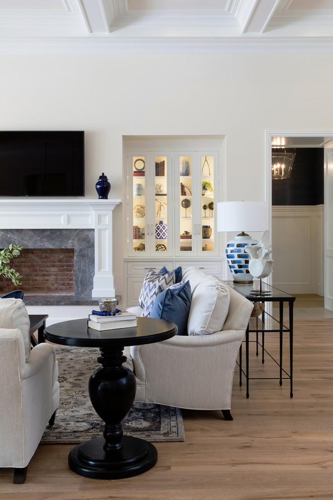 Inspiration for a large transitional open concept living room in San Diego with a home bar, beige walls, medium hardwood floors, a standard fireplace, a stone fireplace surround and a wall-mounted tv.