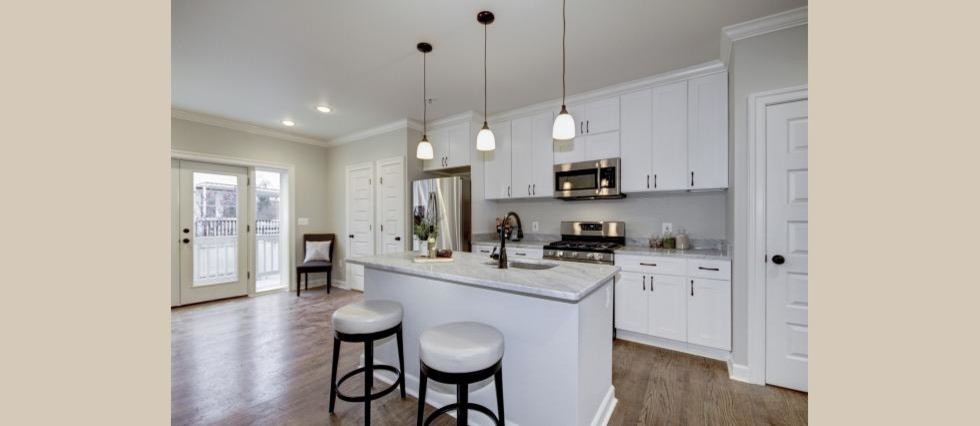 Inspiration for a mid-sized transitional galley medium tone wood floor eat-in kitchen remodel in DC Metro with an undermount sink, shaker cabinets, white cabinets, marble countertops, gray backsplash, stainless steel appliances and an island