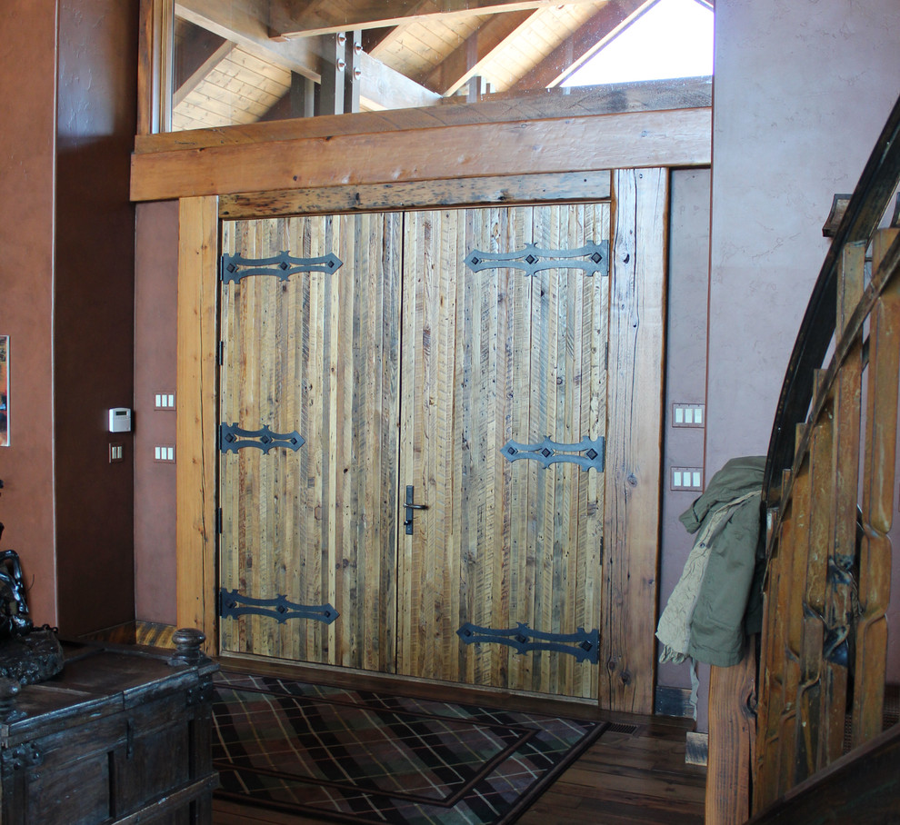Inspiration for a large rustic home design remodel with brown walls and a medium wood front door