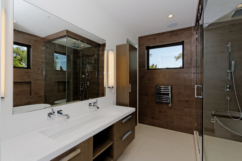 This is an example of a modern master bathroom in San Francisco with a trough sink, flat-panel cabinets, dark wood cabinets, solid surface benchtops and a curbless shower.
